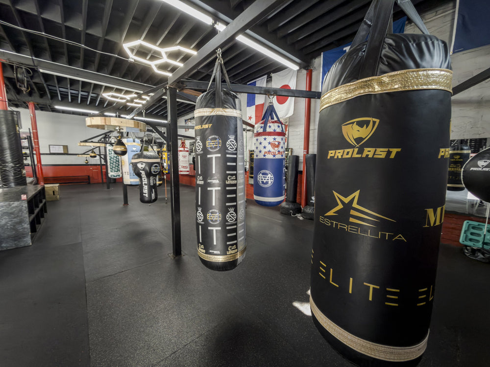 Row of black and gold heavy bags at Knockouts Boxing Facility