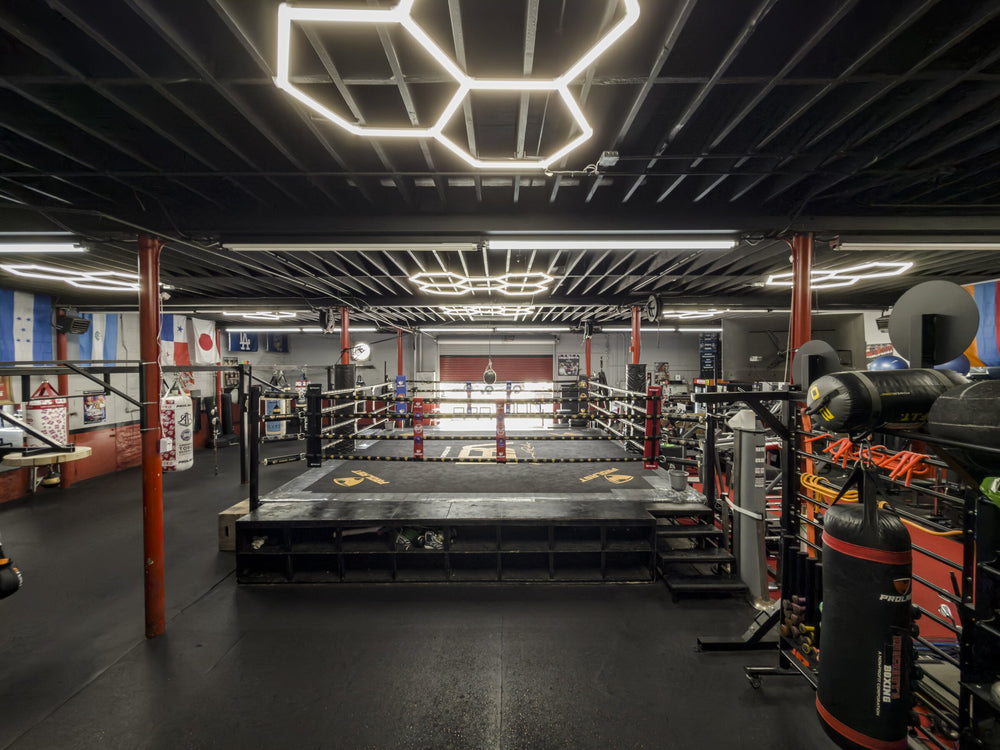 Boxing ring centered beneath hexagonal ceiling lights
